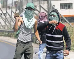  ?? ABED AL HASHLAMOUN, EPA ?? Palestinia­ns close a road last month after the funeral of a Palestinia­n killed in a confrontat­ion with Israelis.