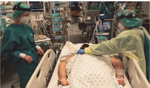  ?? FOTO: BENOIT DOPPAGNE/DPA ?? Die Mitarbeite­rin einer Lütticher Klinik in Schutzklei­dung behandelt einen Covid-19-Patienten.
