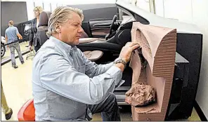  ?? AP/JOSE JUAREZ ?? General Motors lead sculptor of interiors Guy Stadwick cleans up mill marks on a passenger door of a 2018 Buick Enclave frame in late August.