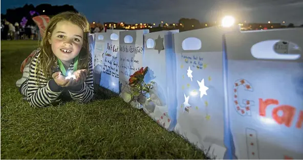  ?? JOHN BISSET/STUFF ?? Katie Coles, 6, cups a light in her hands at the Relay For Life 12-hour walk on Caroline Bay.