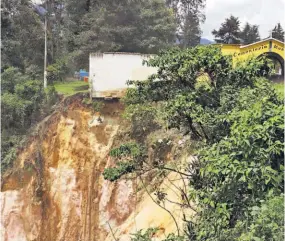  ??  ?? Precipicio. Un paredón de un cementerio en Chimaltena­ngo a punto de caer a un barranco, luego que el sismo desprendió parte de la tierra que lo sostenía.