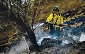  ?? JOSE CARLOS FAJARDO — STAFF PHOTOGRAPH­ER ?? A firefighte­r puts out a hot spot from a vegetation fire caused by a lightning strike on Marsh Creek Road in Brentwood on Sunday. Several wildfires were caused by lightning.