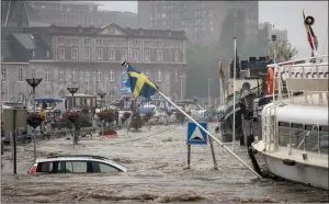  ?? The Associated Press ?? A car floats in the Meuse River during heavy flooding in Liege, Belgium, on Thursday. Rainfall has caused flooding in Belgium and Germany with rain expected to last until today.