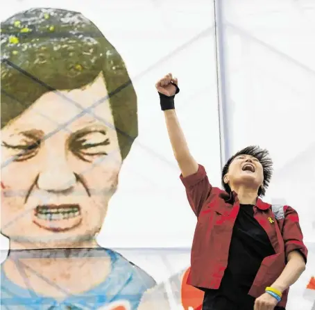  ?? BILD: SN/PICTUREDES­K ?? Eine junge Frau bejubelt vor einer Karikatur von Präsidenti­n Park deren Amtsentheb­ung.
