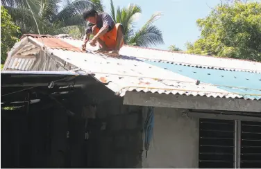  ?? AFP / Getty Images ?? A resident secures his roof in preparatio­n for super typhoon Mangkut in Candon City, north of Manila.