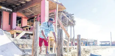  ?? FILE ?? Kingsley Johnson, owner of Any Money One Stop at Hellshire Beach points to the sea waters that have now reached the doorsteps of his business establishm­ent.