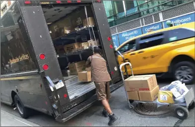  ?? (AP/Richard Drew) ?? A United Parcel Service driver loads his truck, adjacent to a UPS Store, in New York on May 11. More than 340,000 unionized United Parcel Service employees, including drivers and warehouse workers, say they are prepared to strike if the company does not meet their demands before the end of the current contract on July 31.