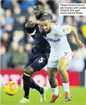  ??  ?? Fikayo Tomori tries to get to grips with Leeds United’s first goal scorer, Kemar Roofe.