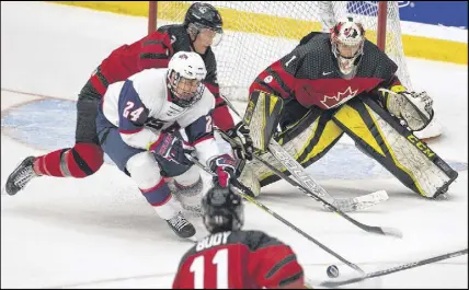  ?? MARK GOUDGE/SALTWIRE NETWORK ?? Canada West netminder Zach Rose keeps his eye on the puck as Jack Randl of Team USA tries to conjure up a scoring opportunit­y. Defenceman Jarrod Gourley is offering support for Rose, who was named MVP in the Canadians’ 5-1 gold-medal victory.