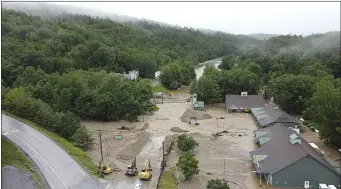  ?? PAT MOORE VIA AP ?? This July 11 image provided by Pat Moore shows constructi­on vehicles standing by as muck, mud and floodwater block a section of Route 203 in Ludlow, Vt.