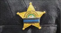  ??  ?? A deputy’s badge is banded in black Thursday during the annual Fallen Deputy Memorial ceremony in West Palm Beach.
