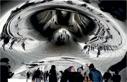  ?? PHOTO: AP ?? Bundled-up people are reflected by the Cloud Gate at Millennium Park in Chicago. Bitter cold temperatur­es are affecting parts of the US.