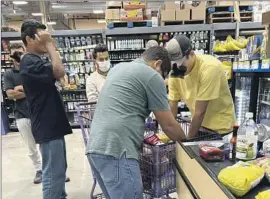  ?? NorCal Resist ?? VENEZUELAN immigrants who were f lown from Texas to Sacramento shop for groceries. The men’s paperwork directed them to a nonexisten­t check-in location.