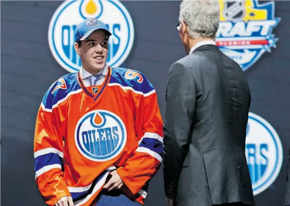  ?? Alan Diaz/The Associat ed Press ?? Connor McDavid, left, chats with former Oilers general manager Craig MacTavish after being chosen by the team in Friday’s NHL entry draft at Sunrise, Fla.