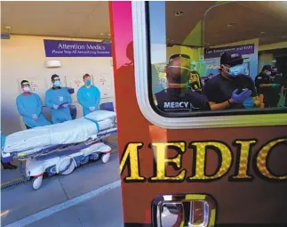  ?? U-T ?? Emergency room personnel wait for paramedics to unload and transfer a newly arrived patient to the ER at the ambulance bay at Sharp Grossmont Hospital in La Mesa on Aug. 12.