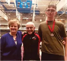  ??  ?? Padraig Cosgrave who put in a strong performanc­e to win silver in the men’s junior 18 1000 metre sprint together with coach Rory Clarke and Mary Cosgrave.