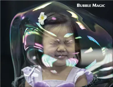  ?? PICTURE: EPA ?? A girl reacts as she stands in a soap bubble during Spanish artist Pep Bou’s Bubble Magic show in Hong Kong, China. The world-renowned bubble artist is in Hong Kong to perform eight shows.