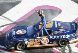  ?? HAKIM WRIGHT SR. — THE ASSOCIATED PRESS ?? Joey Logano stands on his car after winning the NASCAR Cup Series race at Atlanta Motor Speedway on Sunday. It was the first win of the season for the reigning champion.