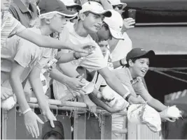  ?? MIKE STOCKER/SUN SENTINEL ?? Young fans try their best to get an autograph from John Isner during the Delray Beach Open tennis tournament after Isner defeated Peter Polansky 6-3, 7-6 (4).