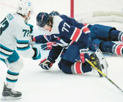  ?? JESS RAPFOGEL/AP ?? Capitals right wing T.J. Oshie (77) defends the empty net and catches a shot by Sharks center Noah Gregor (73) during the third period of Sunday’s game in Washington.