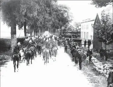  ?? THE ASSOCIATED PRESS ?? Lancers on horseback enter a Belgium village in the first days of the war on the Western Front in a 1914 photo. They were messengers, spies, sentinels and the heavy haulers of World War I, carrying supplies, munitions and food and leading cavalry charges. The horses, mules, dogs and pigeons were a vital part of the Allied war machine, saving countless lives — and dying by the millions. were awarded France’s Croix de Guerre, or War Cross.