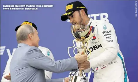  ??  ?? Russlands Präsident Wladimir Putin überreicht Lewis Hamilton den Siegerpoka­l.