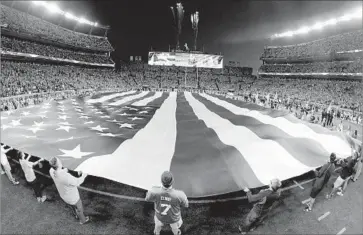  ?? Jack Dempsey ?? THE NFL has maintained that although ratings have slipped this year, its telecasts still dwarf everything else on TV. Above, the f lag is displayed during the national anthem prior to an NFL game Monday in Denver.