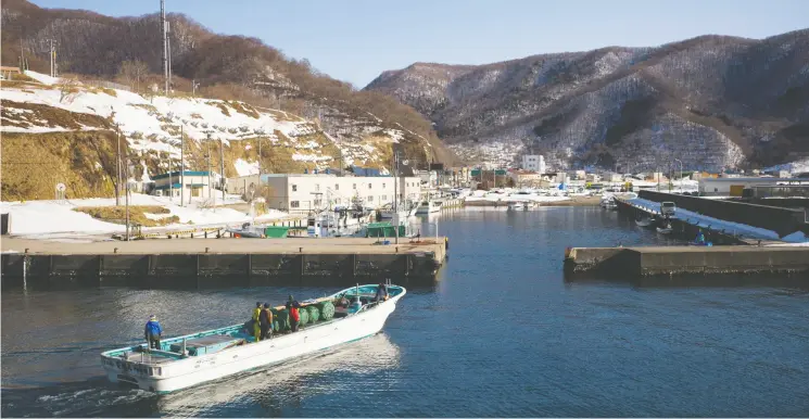  ?? KENTARO TAKAHASHI / BLOOMBERG ?? A fishing boat returns to a port in Kamoenai, one of two villages in the northern Japanese prefecture of Hokkaido vying to host a permanent storage site for nuclear waste.