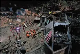  ?? CHINATOPIX VIA AP ?? Rescuers search Saturday for victims of a landslide triggered by Typhoon Lekima in Yongjia county in eastern China’s Zhejiang province. The official Xinhua News Agency said more than 1 million people were evacuated in coastal Zhejiang province before the typhoon hit land at 1:45 a.m.