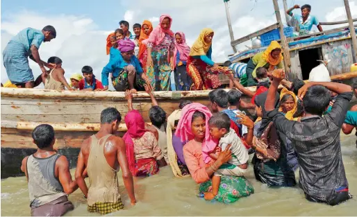  ?? Reuters ?? Rohingya refugees get off a boat after crossing the Bangladesh-Myanmar border through the Bay of Bengal, in Shah Porir Dwip, Bangladesh. —