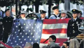  ?? REUTERS ?? New York police and firefighte­rs hold the US flag during a ceremony marking the 20th anniversar­y of the September 11 attacks, in New York on Saturday.