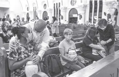  ?? AFP ?? Fr. Flavie Villanueva – a priest who has received death threats and been charged with sedition for his criticism of President Duterte’s bloody drug war – comforts family members of those killed in the anti-narcotics campaign during a ceremony at the Sacred Heart Parish Shrine in Quezon City in a photo taken on June 20.