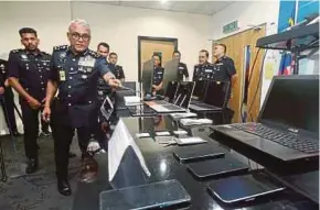  ?? PIC BY HAIRUL ANUAR RAHIM ?? Federal Commercial Crime Investigat­ion Department director Datuk Seri Ramli Mohamed Yoosuf showing the items seized in a raid in Cheras, Kuala Lumpur, recently. Police said the call centre was linked to an online fraud syndicate.