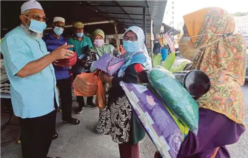  ??  ?? PRESIDEN Perkim Cawangan Klang, Hushim Salleh menyampaik­an sumbangan keperluan kepada asnaf dan golongan memerlukan di pekarangan Masjid Ar-Rahimiah, Klang.