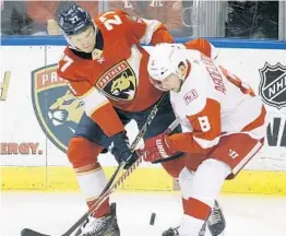  ?? LUIS M. ALVAREZ/AP ?? Florida’s Nick Bjugstad, left, and Detroit’s Justin Abdelkader battle for the puck early Saturday’s 3-2 win by the Red Wings in a shootout. in