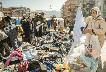  ?? SERGEY PONOMAREV/THE NEW YORK TIMES ?? Earthquake survivors sift through donated clothes Thursday in Antakya, Turkey. President Recep Tayyip Erdogan called the 7.8 magnitude earthquake, which struck Monday,“the disaster of the century.”