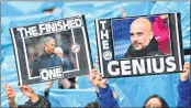  ??  ?? Manchester City fans hold up placards showing the faces of Manchester City's manager Pep Guardiola (R) and Manchester United's manager Jose Mourinho at the Etihad Stadium recently.