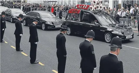  ?? Pictures: PA/Getty. ?? The hearse bearing the floral tribute ‘No 1 daddy’ makes its way down a road flanked by police officers.