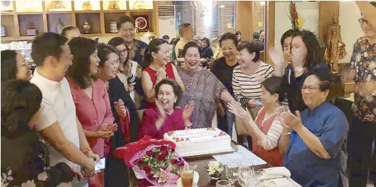  ??  ?? Surrounded by family and friends, Birthday Girl Susan Roces flashes a big smile after blowing the candle on the cake brought by Carlitos Siguion-Reyna and wife Bibeth Orteza