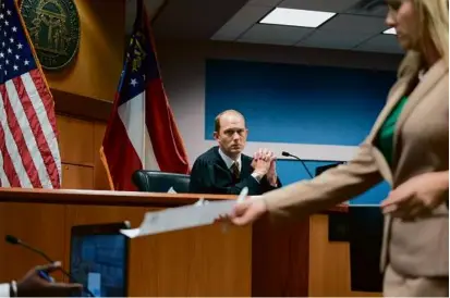  ?? BRYNN ANDERSON-POOL/GETTY IMAGES ?? Judge Scott McAfee looked on as attorney Ashleigh Merchant handled a document during a hearing in the case against Donald Trump at the Fulton County Courthouse in February.