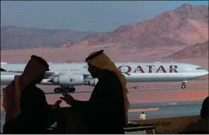  ?? (AP/Amr Nabil) ?? Journalist­s chat as video of a plane carrying Qatari Emir Sheikh Tamim bin Hamad Al Thani is shown on a screen while landing at at Al Ula airport this week before the start of the Gulf Cooperatio­n Council meeting in Saudi Arabia.