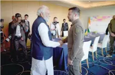  ?? — Reuters ?? Ukraine’s President Volodymyr Zelenskiy and Indian PM Narendra Modi shake hands during the G7 leaders’ summit in Hiroshima, Japan.