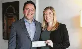  ??  ?? Carl Salazar, executive director of HomeAid Houston, is presented a check for $9,427.34 from Stephanie Finch with Finch Properties. The funds were raised at the annual Finch Properties Charity Fish Fry.