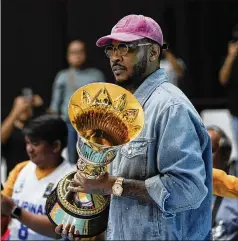  ?? AARON FAVILA/ASSOCIATED PRESS ?? FIBA Global Ambassador Carmelo Anthony carries a trophy at the FIBA Basketball World Cup 2023 Asian Qualifiers on Friday at the Philippine Arena in Bulacan province, north of Manila, Philippine­s.