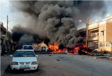  ?? AP ?? Cars and buildings burn after two car bomb explosions in the Kurdish-controlled centre of Qamishli in northeaste­rn Syria. Islamic State claimed responsibi­lity for the attack, which coincided with Turkey’s invasion of the area.