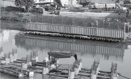  ?? FRIZAL/JAWA POS ?? TERUS BERJALAN: Sejumlah pekerja menyelesai­kan konstruksi jembatan yang menghubung­kan dua sisi Kali Jagir.