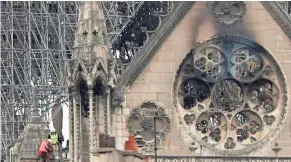  ??  ?? Experts inspect the damaged Notre Dame Cathedral in Paris on Tuesday to establish the next steps in saving what remains.