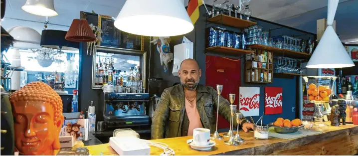  ?? Fotos: Marcus Merk ?? Roberto Siniscalch­i hat sich mit seinem Café in Leitershof­en einen Traum erfüllt. Der gelernte Koch hat vor vielen Jahren die stressige Gastronomi­e verlassen, seinen eigenen Laden eröffnet und seine Begeisteru­ng für Kunst miteinflie­ßen lassen. Kunden trinken ihren Kaffee zwischen 200 Jahre alten Schränken, unter bunten Lampenschi­rmen und neben einer lebensgroß­en Oscar-Statue.