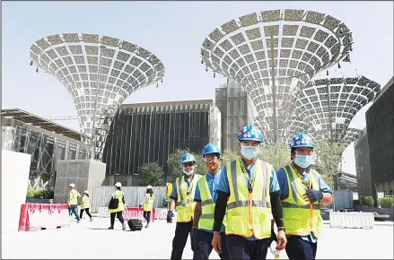  ??  ?? In this file photo, technician­s walk at the three thematic districts at the under constructi­on site of the Expo 2020 in Dubai, United Arab Emirates. (AP)