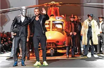  ??  ?? Designer Philipp Plein (center) greets the audience at the end of the show for fashion house Billionair­e during the Men's Fall-Winter 2017-2018 fashion week in Milan.